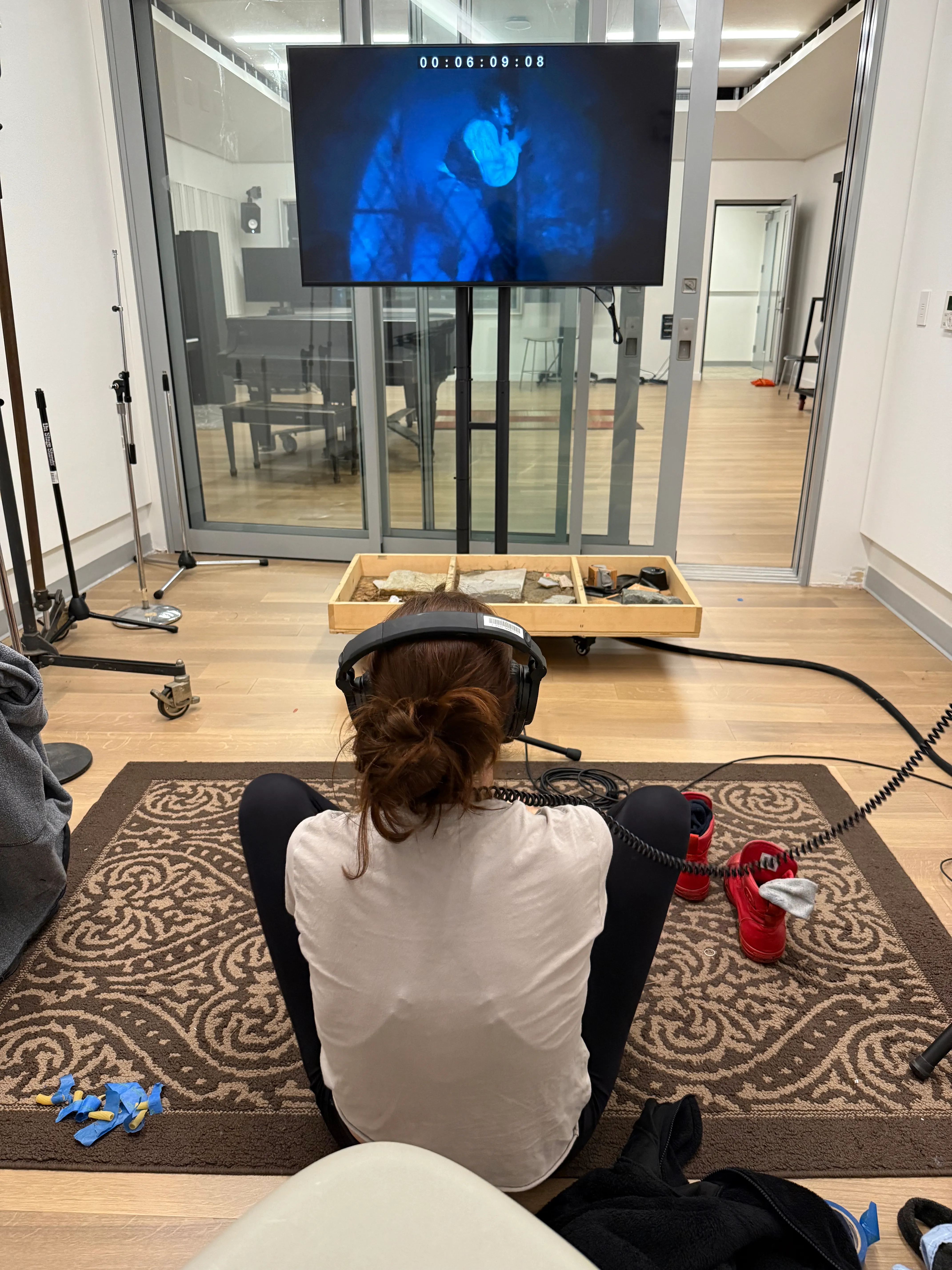 Madison focused on her performance while looking at TV; reverse angle.